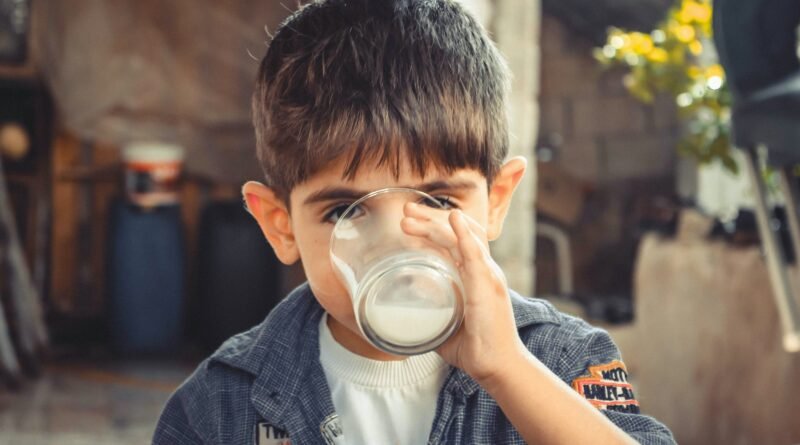 photo of boy drinking glass of milk